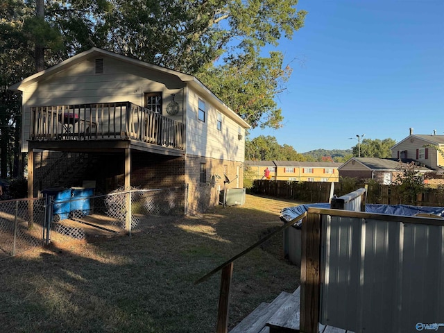 view of home's exterior featuring a lawn and a swimming pool side deck