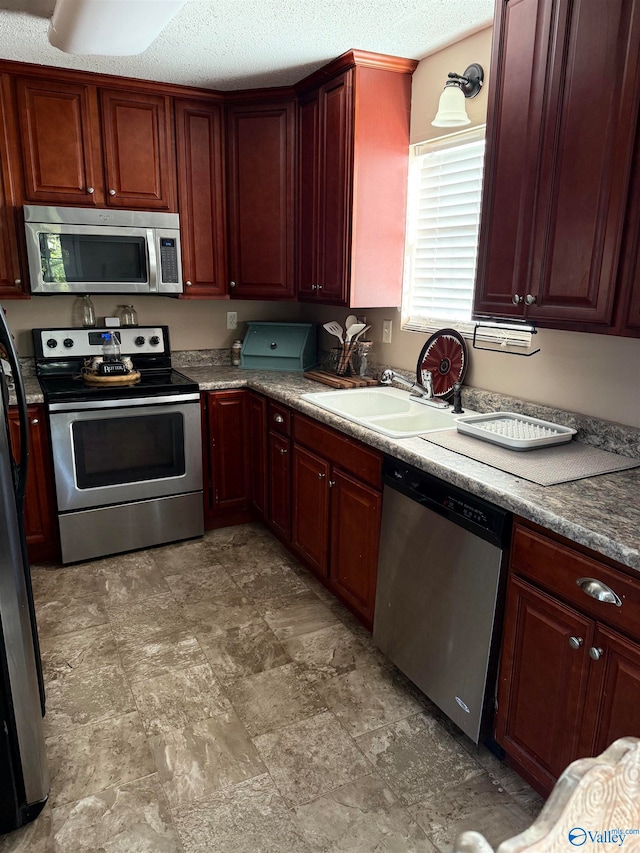 kitchen featuring a textured ceiling, appliances with stainless steel finishes, and sink