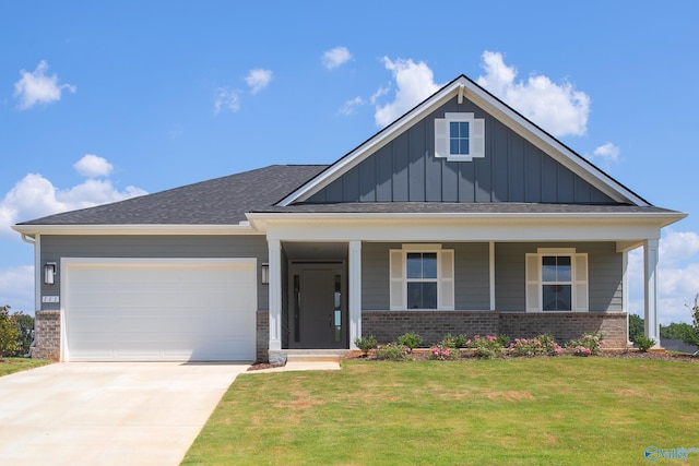 view of front of home featuring a garage, covered porch, and a front lawn