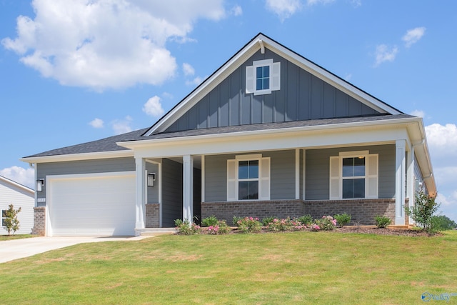 view of front of house with a garage, a front yard, and a porch