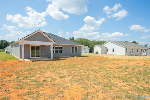 rear view of house featuring a yard and a patio area