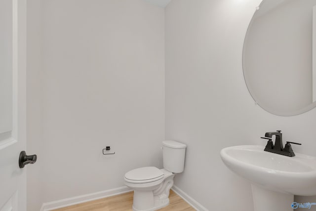 bathroom with wood-type flooring, sink, and toilet