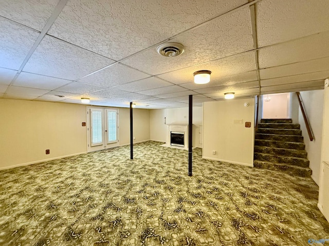 basement featuring carpet floors and a drop ceiling