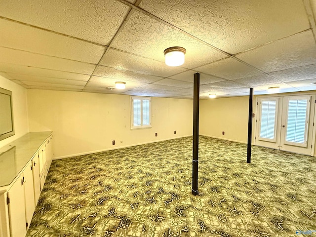 basement with carpet floors and a drop ceiling