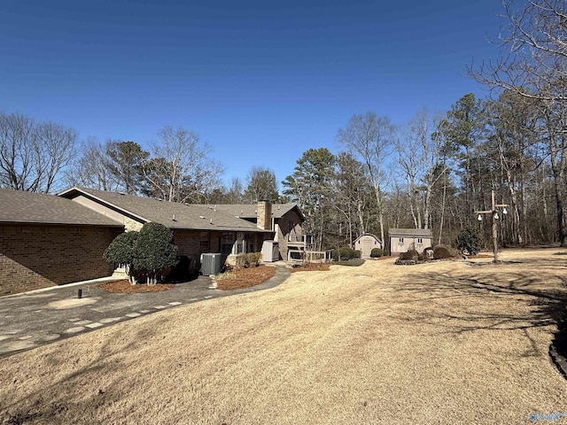 view of property exterior featuring central AC unit and a storage unit