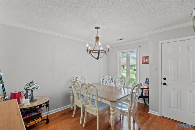 2413 Remington Cir SW, Decatur, AL 35601 - dining space featuring a chandelier, wood finished floors, ornamental molding, and a textured ceiling