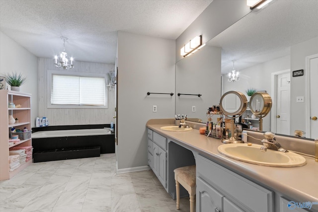 2413 Remington Cir SW, Decatur, AL 35601 - full bath with a chandelier, a bathtub, double vanity, a textured ceiling, and marble finish flooring
