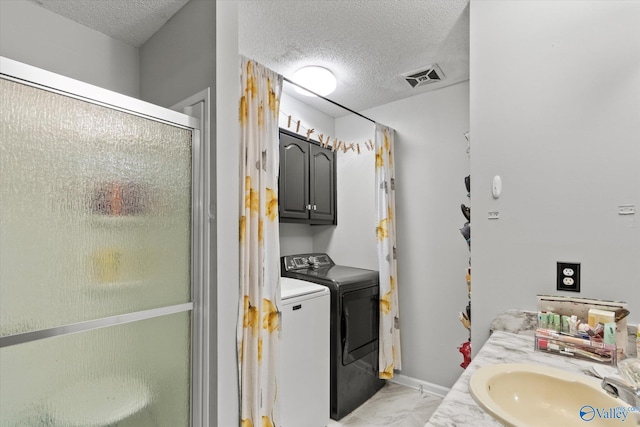 2413 Remington Cir SW, Decatur, AL 35601 - bathroom with washer and clothes dryer, a textured ceiling, marble look tile flooring, a stall shower, and vanity