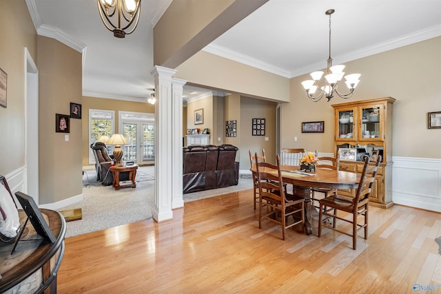 dining room with an inviting chandelier, ornamental molding, light hardwood / wood-style floors, and ornate columns