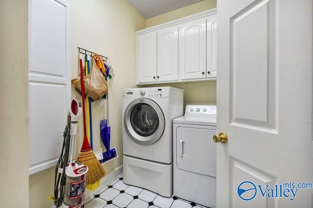 laundry area featuring washer and clothes dryer and cabinets