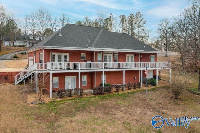 rear view of property featuring a wooden deck, a yard, and french doors