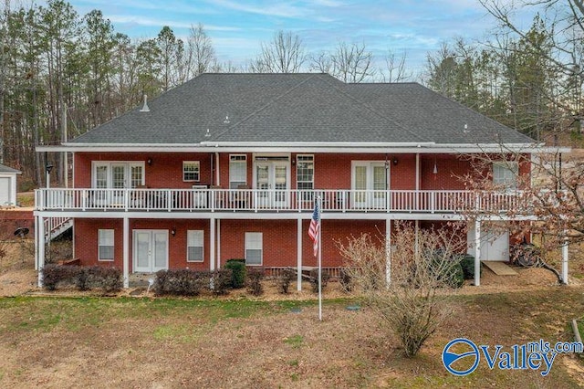 rear view of property featuring a wooden deck, a lawn, and french doors