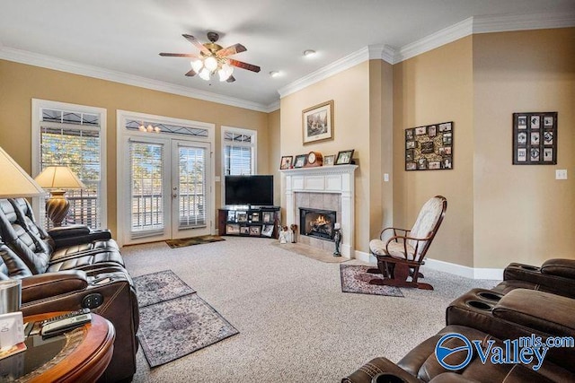 carpeted living room featuring a tiled fireplace, crown molding, french doors, and ceiling fan