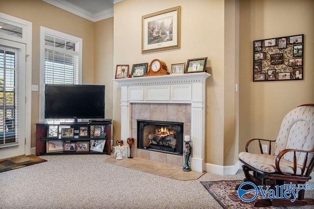 living area featuring a tiled fireplace, crown molding, and carpet floors