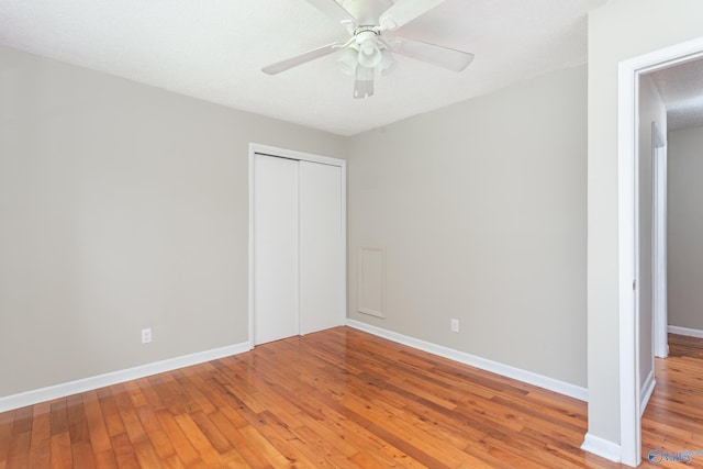 unfurnished bedroom featuring wood-type flooring, a closet, and ceiling fan