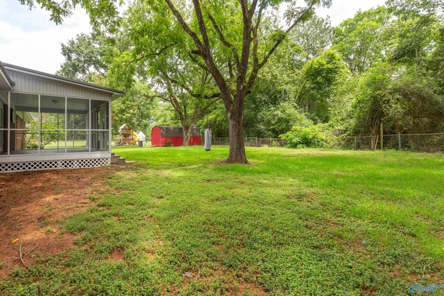 view of yard with a storage shed and a sunroom