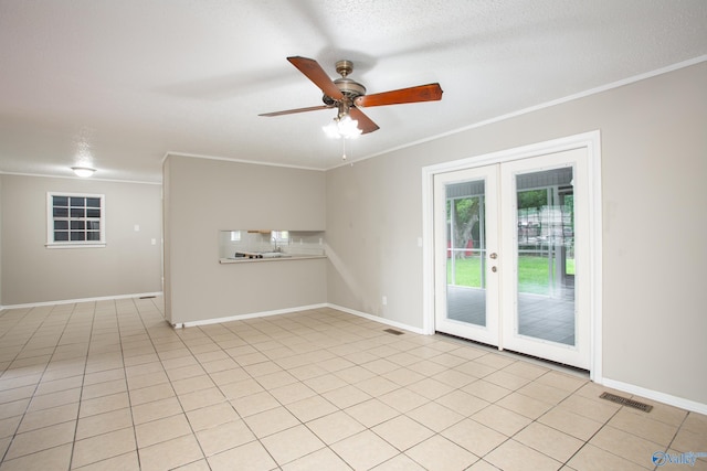 tiled empty room with crown molding, french doors, ceiling fan, and a textured ceiling