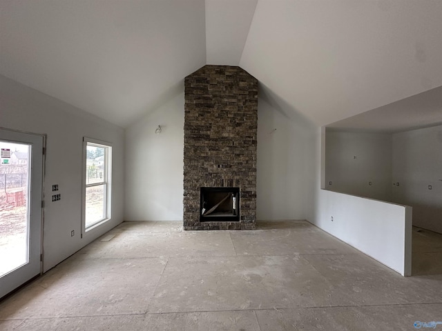 unfurnished living room featuring a stone fireplace and high vaulted ceiling