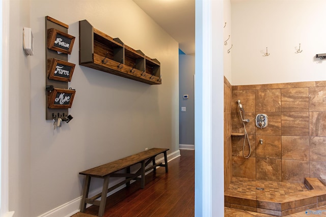 bathroom with hardwood / wood-style flooring and tiled shower