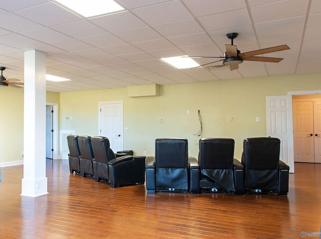 cinema room featuring ceiling fan, a paneled ceiling, hardwood / wood-style floors, and ornate columns