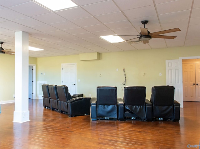 cinema room featuring hardwood / wood-style flooring, a paneled ceiling, ceiling fan, and ornate columns