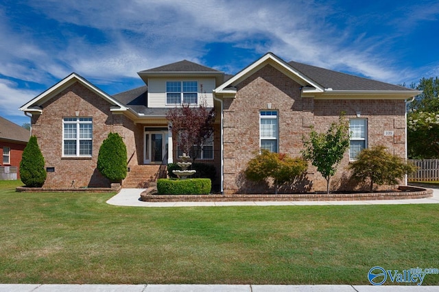 view of front of home featuring brick siding, a front yard, and fence