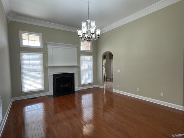 unfurnished living room with crown molding, baseboards, a fireplace with flush hearth, arched walkways, and dark wood-style floors