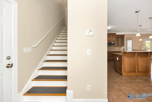 stairway featuring tile patterned flooring and ornamental molding