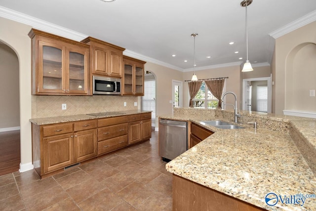 kitchen with arched walkways, a sink, decorative backsplash, stainless steel appliances, and brown cabinets