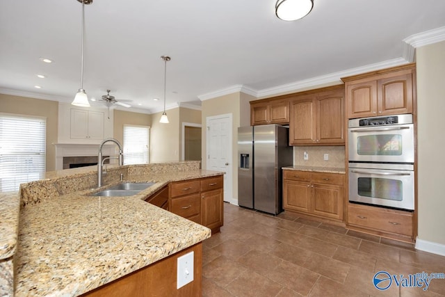 kitchen with a sink, stainless steel appliances, brown cabinets, and backsplash