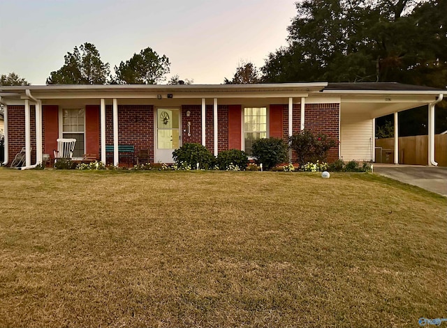 ranch-style house featuring a lawn and a carport