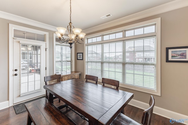 dining space with dark wood-style flooring, baseboards, a chandelier, crown molding, and visible vents