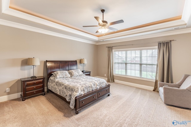 bedroom featuring a raised ceiling, crown molding, light colored carpet, and baseboards