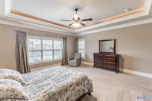 bedroom featuring a raised ceiling, crown molding, baseboards, and carpet