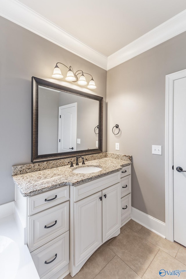 bathroom with tile patterned flooring, vanity, baseboards, and crown molding
