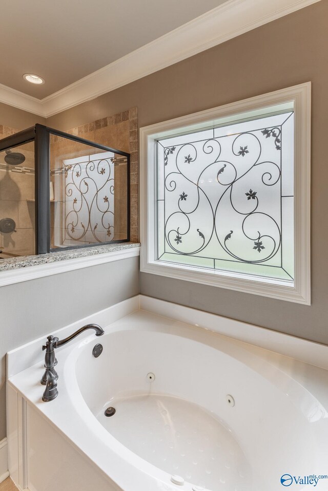 bathroom with crown molding, a whirlpool tub, and tiled shower