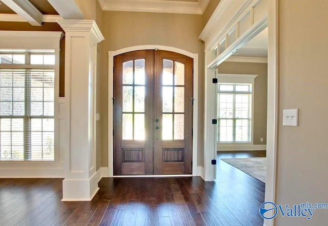 foyer entrance with arched walkways, french doors, crown molding, and dark wood-style floors