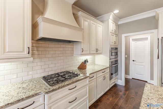 kitchen with light stone countertops, dark wood-type flooring, ornamental molding, stainless steel appliances, and custom range hood