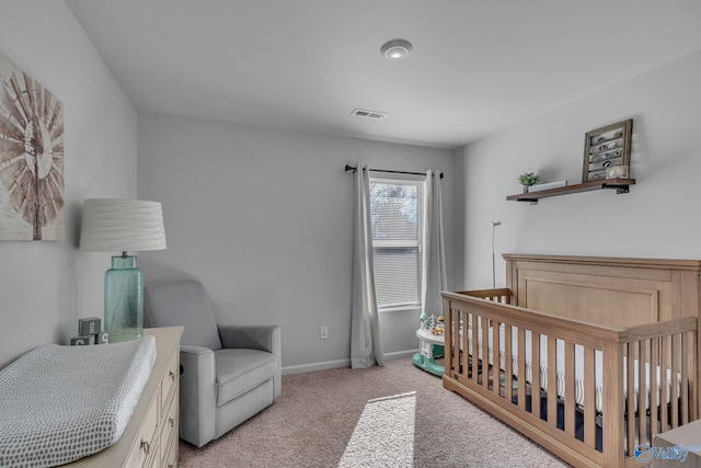 bedroom featuring light colored carpet and a nursery area