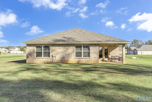 rear view of property with a lawn and a patio area