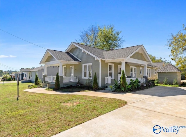 view of front of home with a front yard, a garage, and a porch