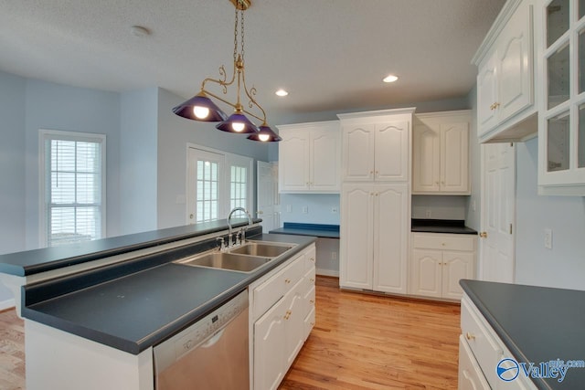 kitchen with a sink, dark countertops, recessed lighting, white cabinetry, and dishwashing machine