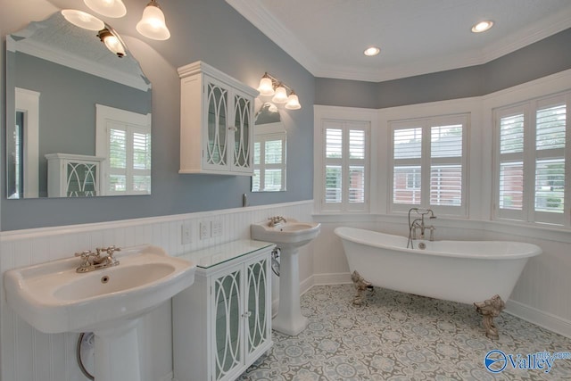 full bath with recessed lighting, a wainscoted wall, a freestanding bath, ornamental molding, and a sink