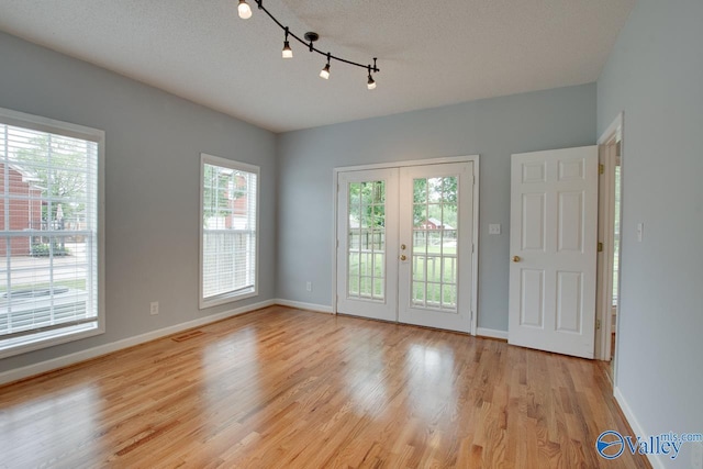 interior space with plenty of natural light, baseboards, and a textured ceiling