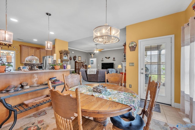 dining area featuring crown molding, ceiling fan with notable chandelier, and light tile patterned floors