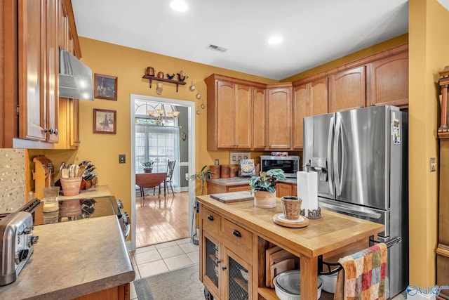 kitchen featuring ventilation hood, stainless steel appliances, and light wood-type flooring