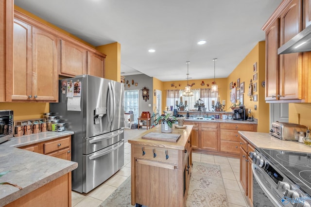 kitchen with light tile patterned floors, appliances with stainless steel finishes, a center island, and decorative light fixtures