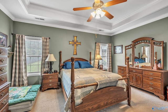 bedroom with ceiling fan, a raised ceiling, ornamental molding, and light colored carpet