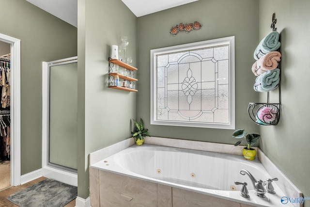 bathroom featuring wood-type flooring and shower with separate bathtub