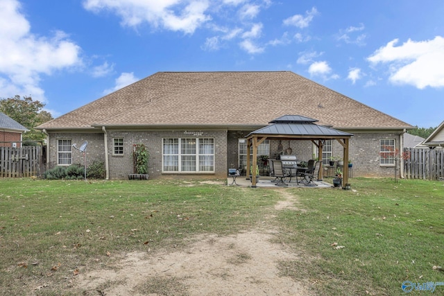 rear view of property featuring a gazebo, a patio, and a lawn